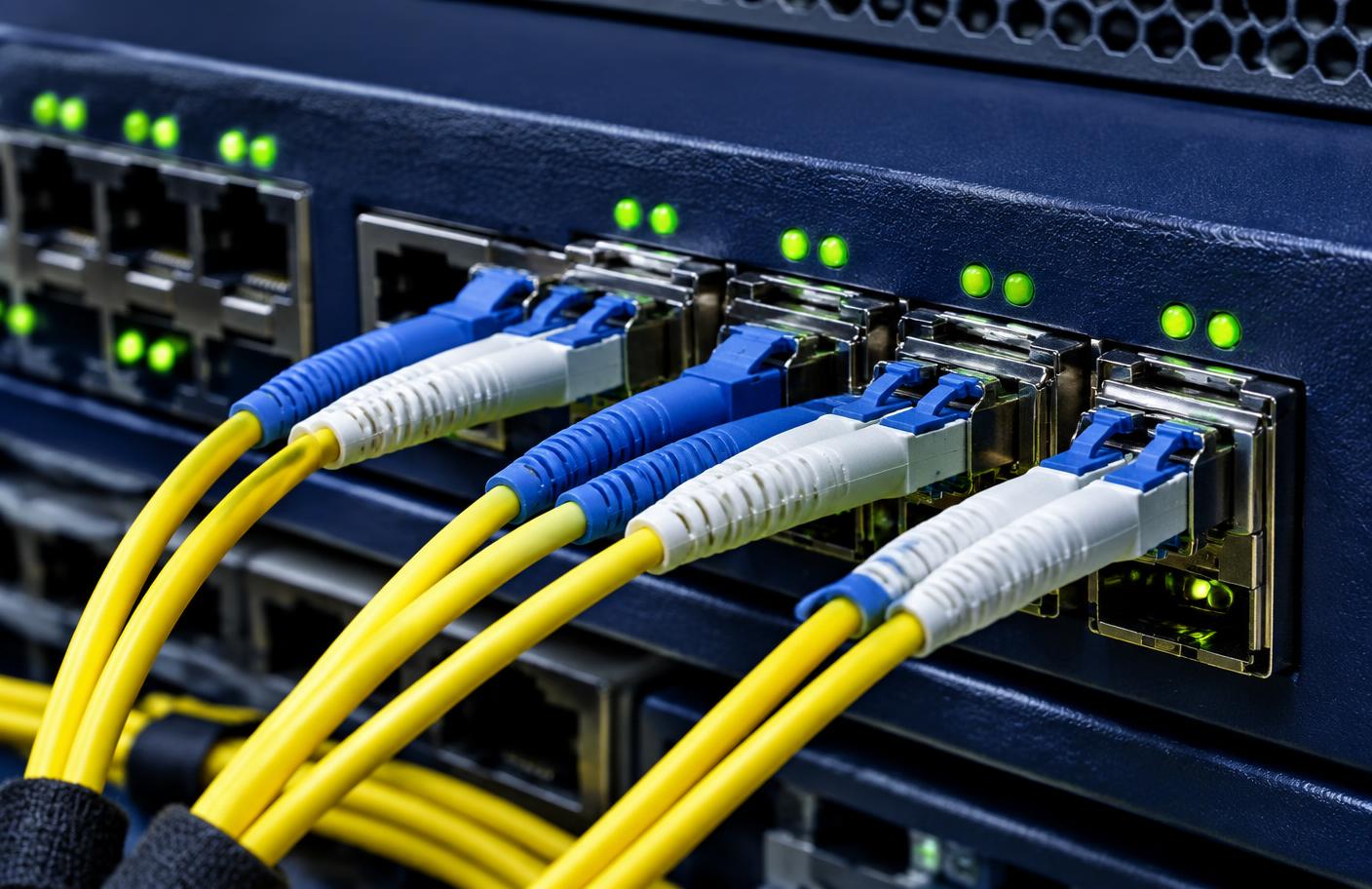 Yellow fibre optic cables plugged into a network switch